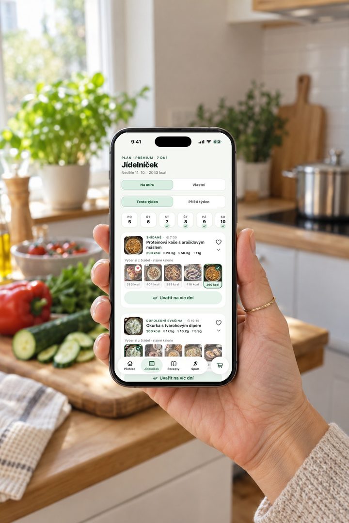 Ruka drží telefon s týdenním jídelníčkem v kuchyni